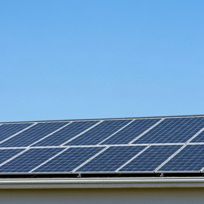 Modern solar panels on a residential rooftop with a clear blue sky, demonstrating clean energy and home value increase